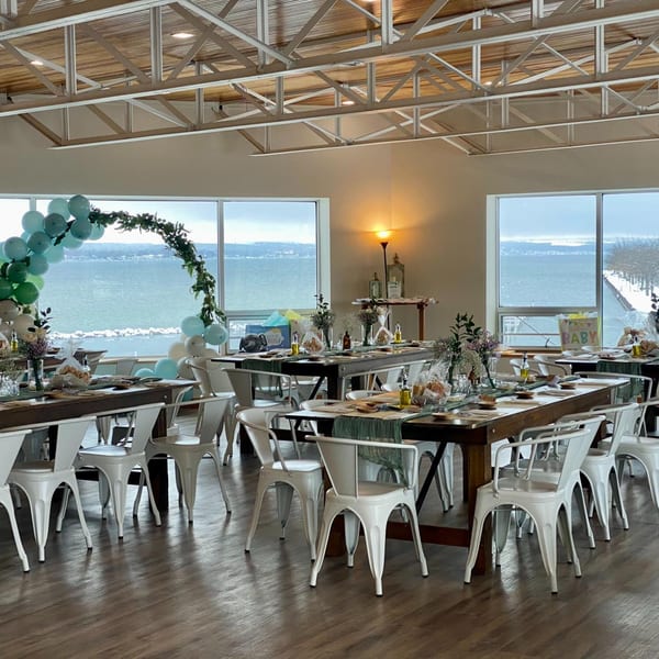 A COHO Pizza & Wine Bar dining room set for an event with lake views and balloon decor.