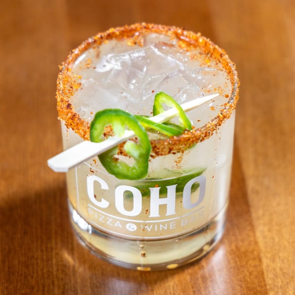 A COHO Pizza & Wine Bar cocktail with ice, jalapeño slices, and a chili-lime rim.