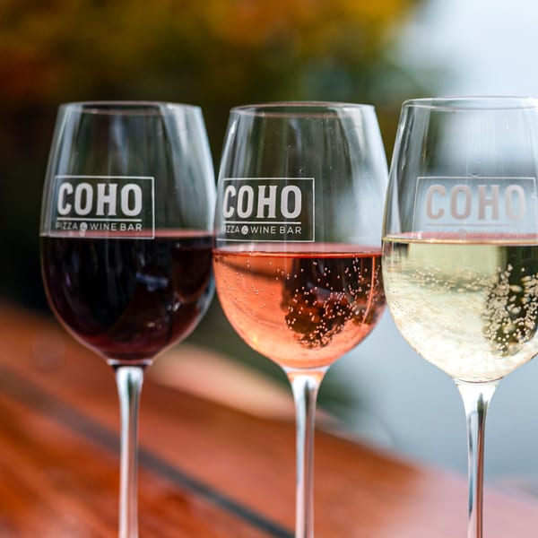 Three COHO Pizza & Wine Bar glasses filled with red, rosé, and white sparkling wine.
